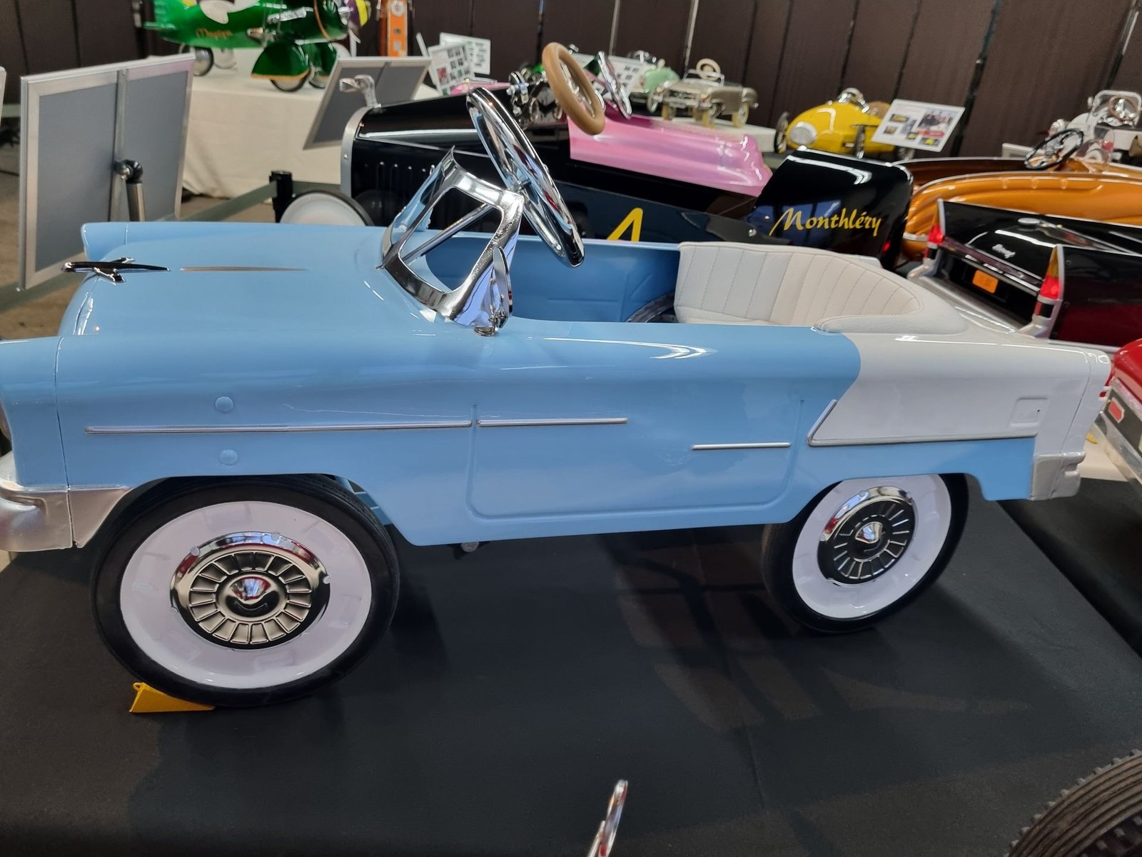 In einem Museum steht ein blau-weißes Tretauto.